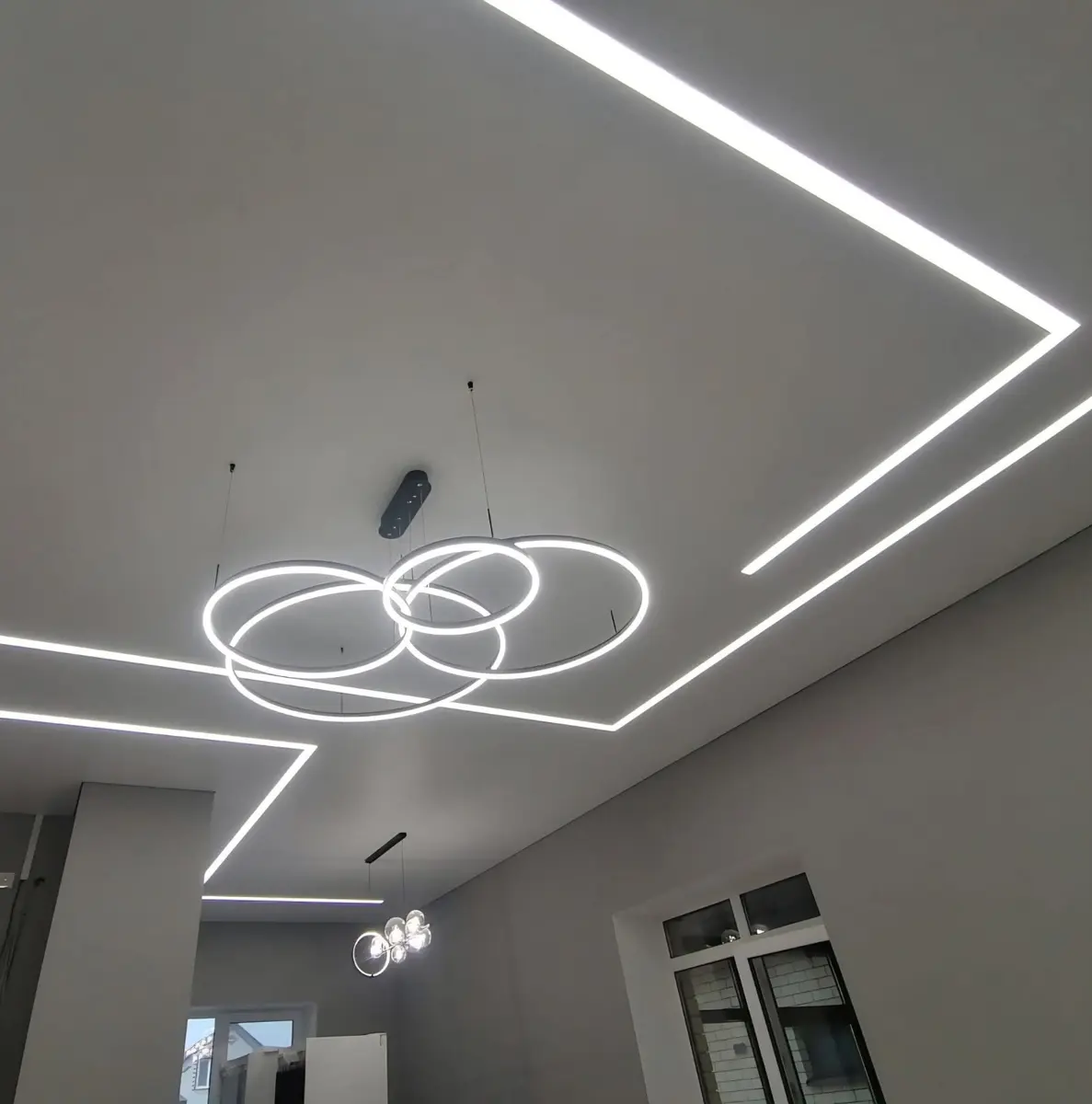 Mūsų įrengtos svetainės lubos su geometrinėmis šviesos linijomis